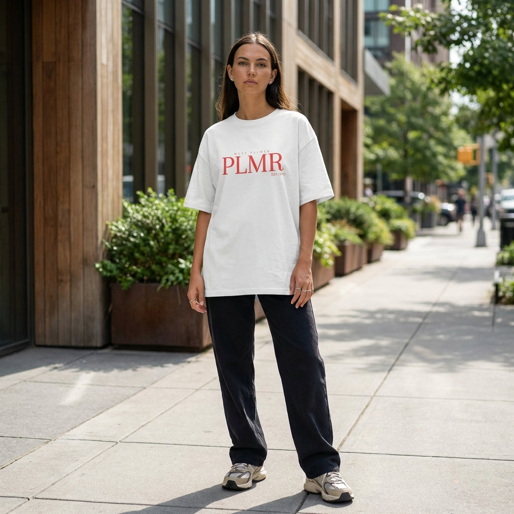 Full-body shot of a model in an oversized t-shirt standing confidently on a city street with natural daylight, showcasing relaxed style and fabric texture.